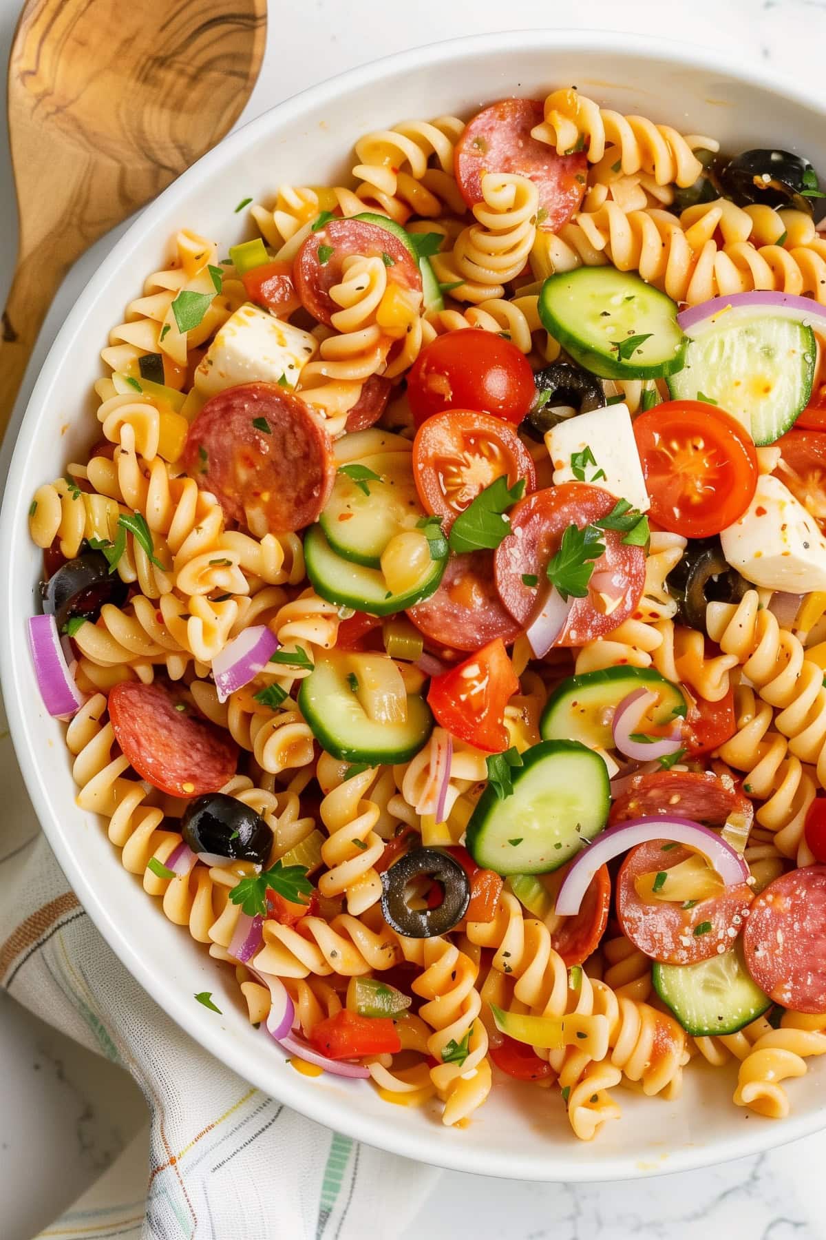 Supreme pasta salad, featuring fusilli, cucumber, cherry tomatoes, pepperoni, mozzarella and onions. 