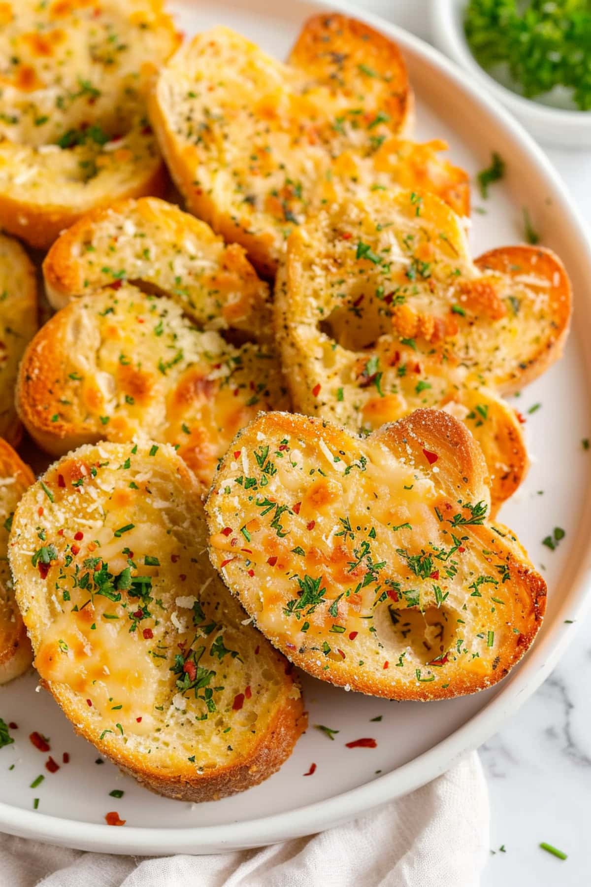 Bunch of garlic bread on a white plate.