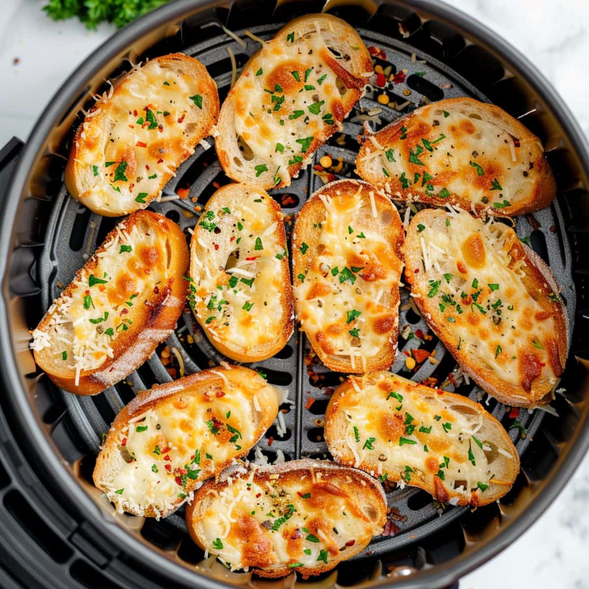 Garlic breads inside an air fryer basket. 