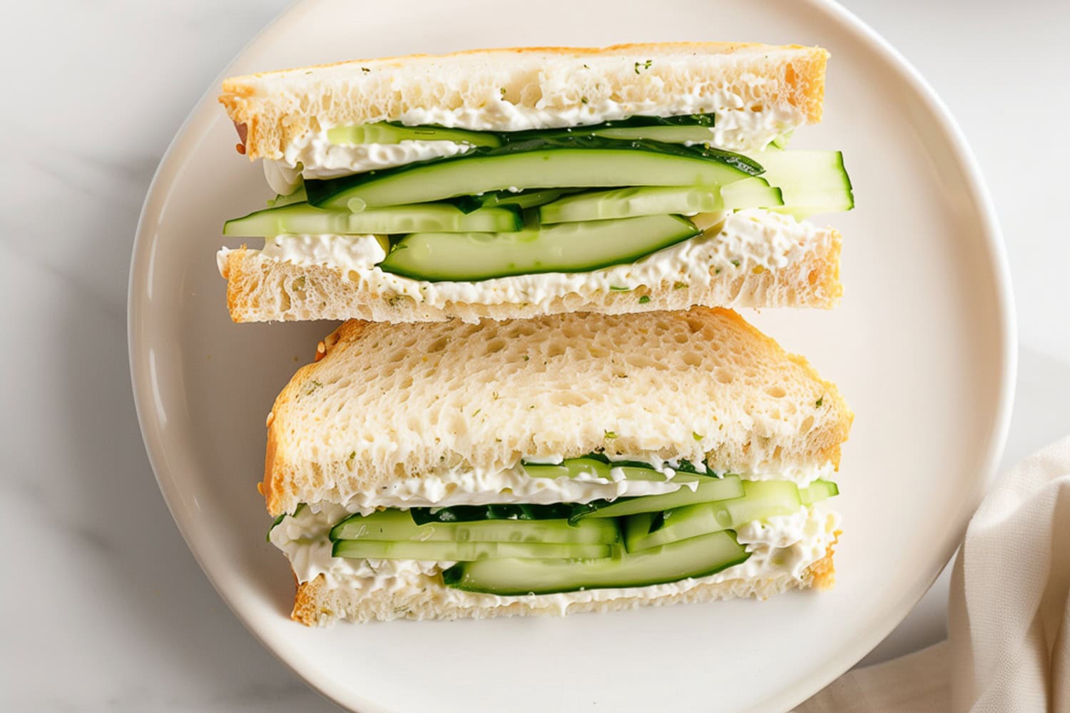 Homemade cucumber sandwiches with a spread of herb-infused cream cheese.