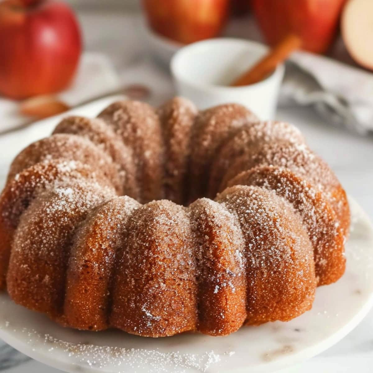 Whole apple cider donut bundt cake in a white plate.