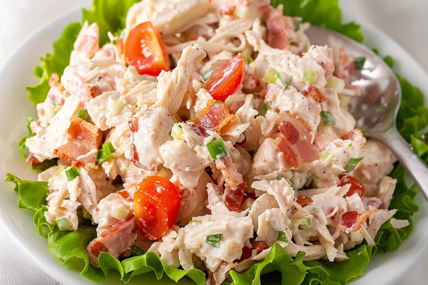 A hearty BLT Chicken salad with fresh cherry tomatoes, bacon bits and chopped chives for garnish.