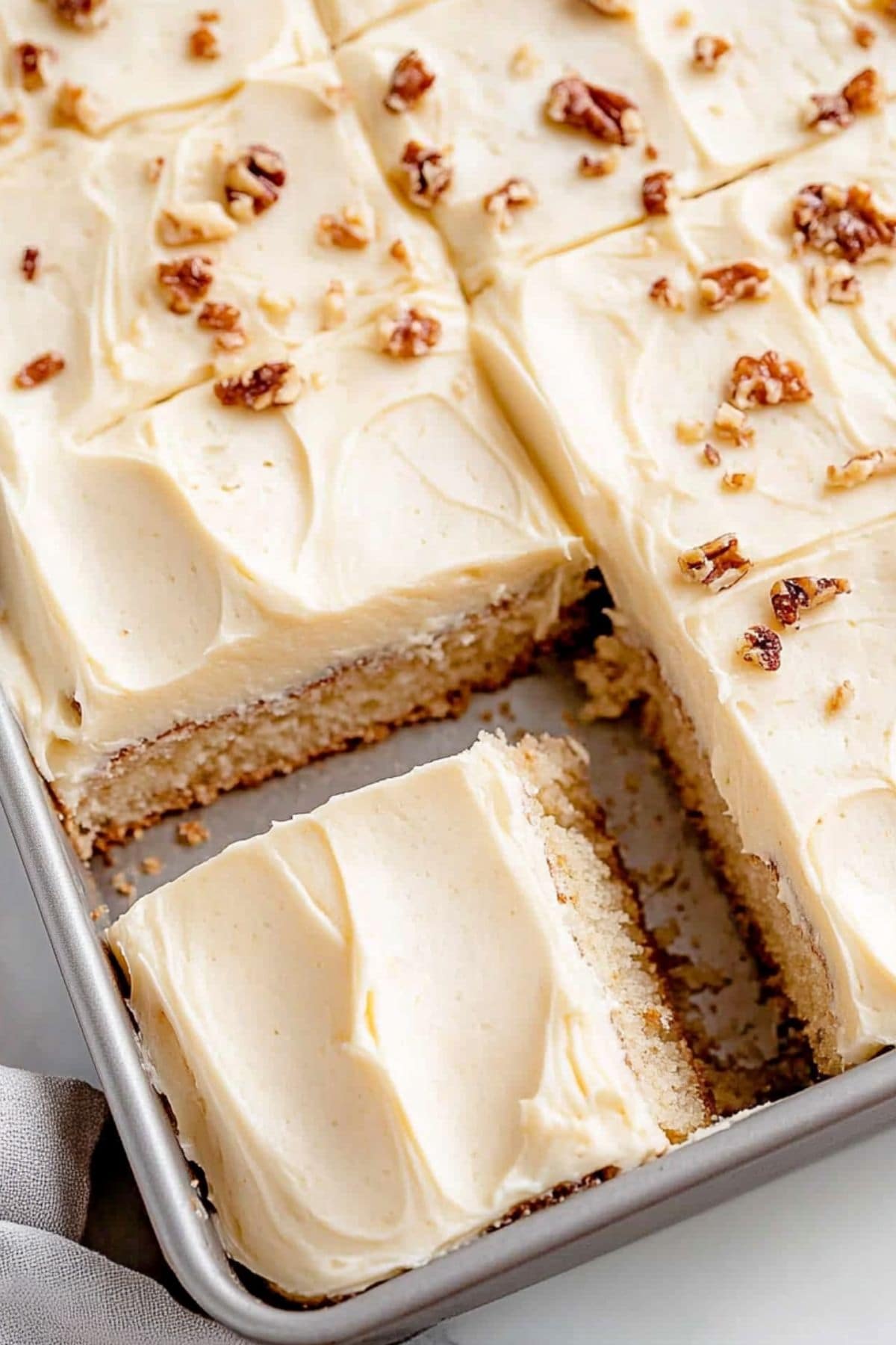 Banana Bread Bars with brown butter frosting and walnuts in a baking pan