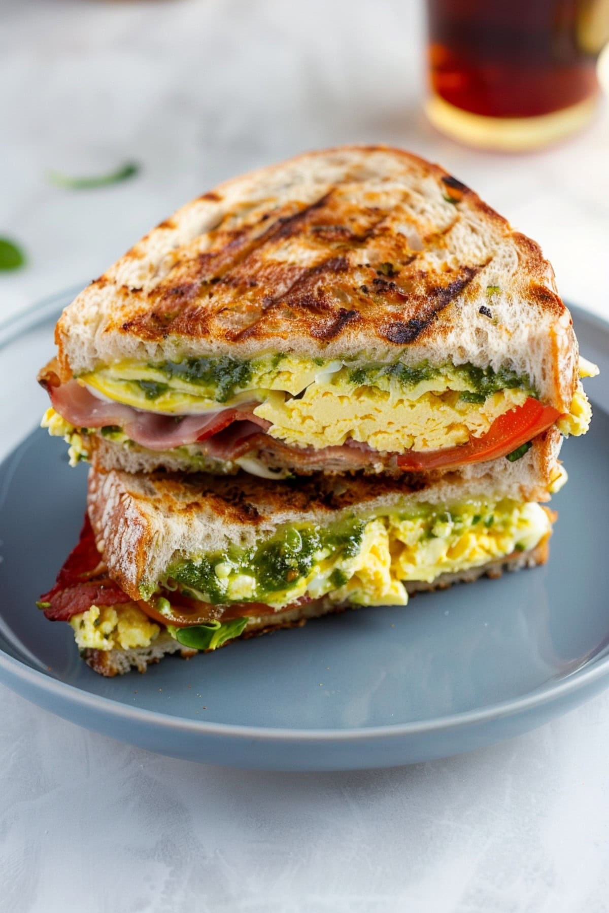 Breakfast Panini with Scrambled Eggs, Bacon, Tomatoes and Pesto.