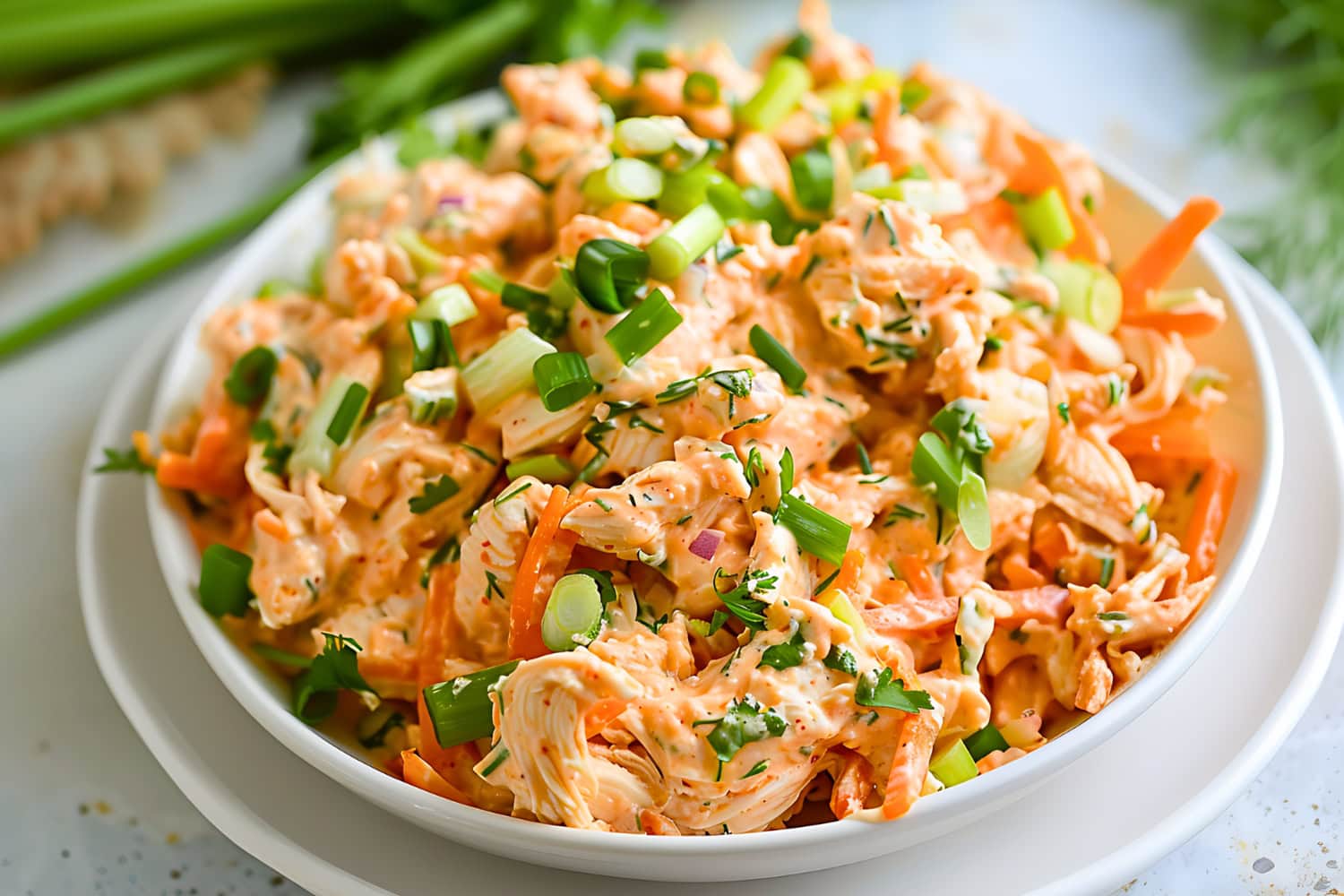 Buffalo chicken salad served on a white bowl.