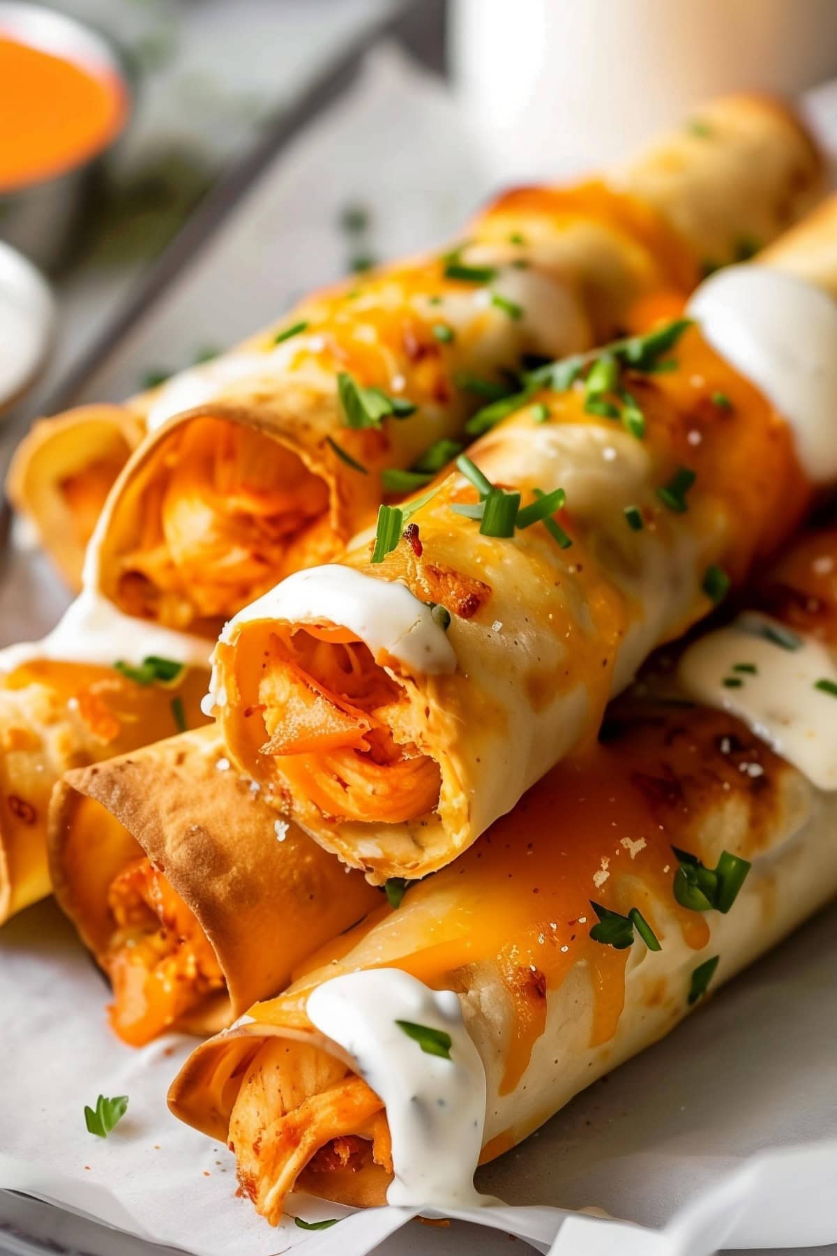 Crispy buffalo chicken taquitos with a golden tortilla shell, close up.