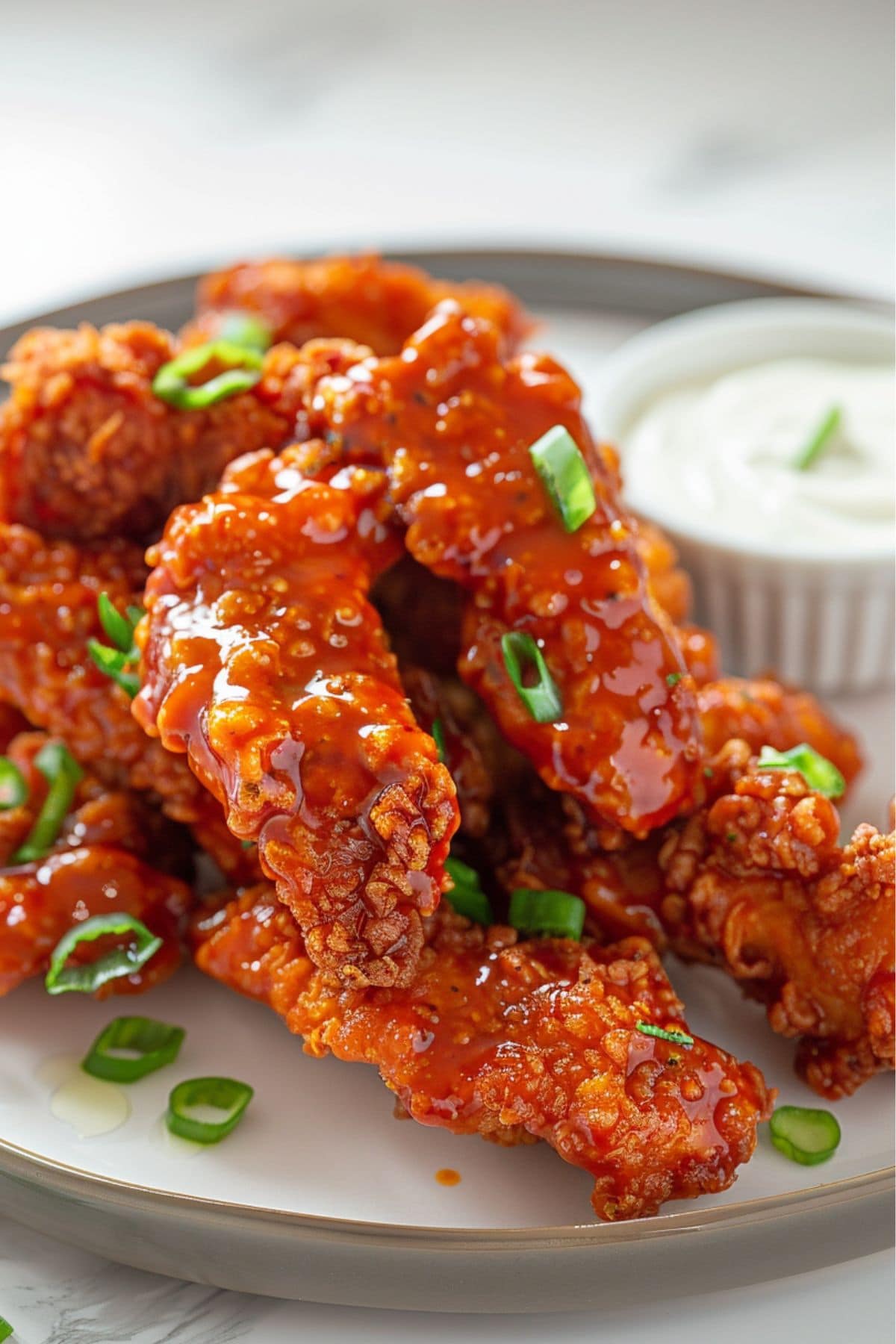 Buffalo chicken tended served on a plate with ranch dip.