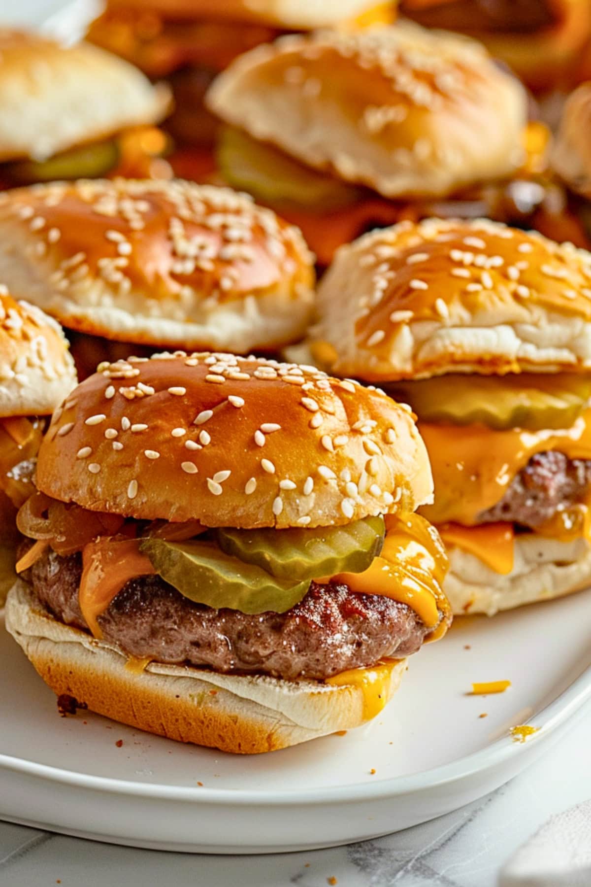 Pulled apart cheeseburger slides arranged in a white plate.