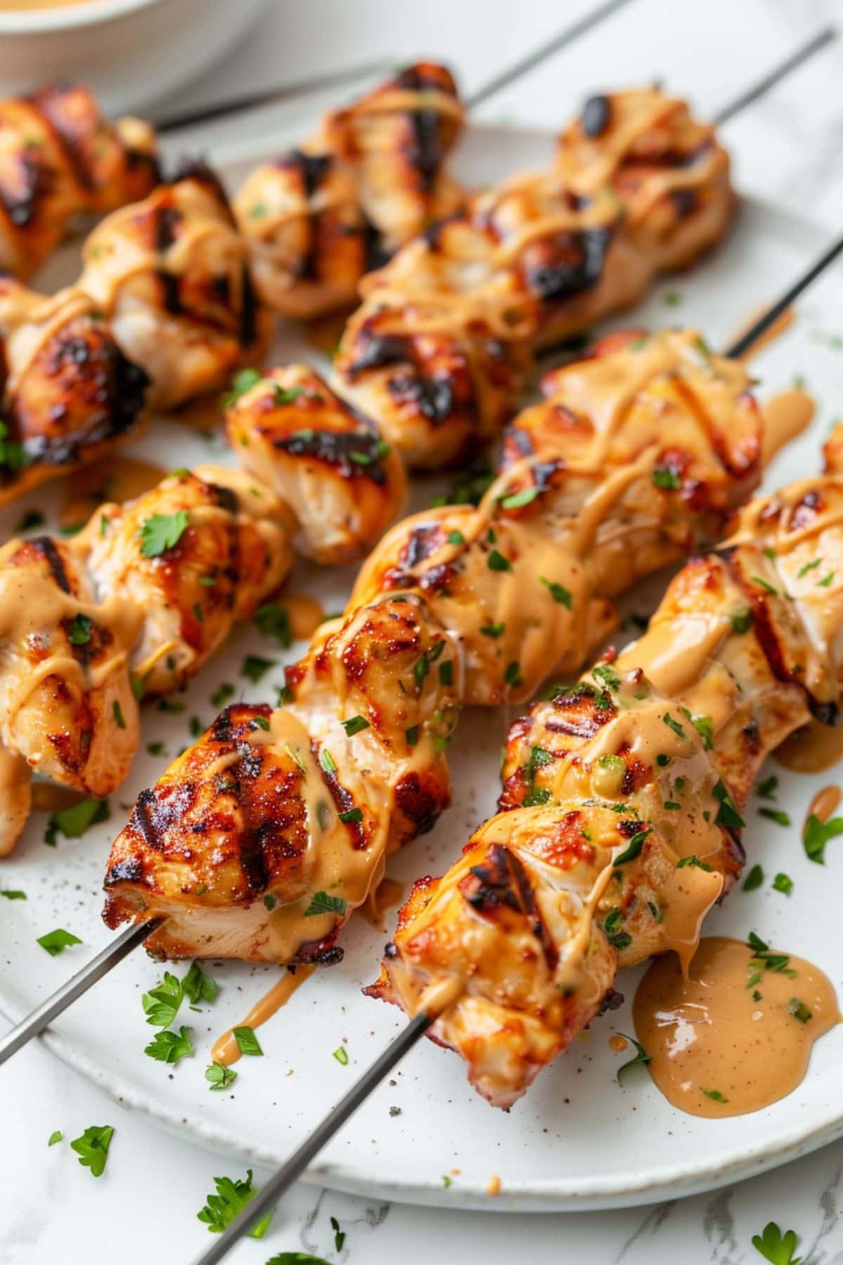 Skewered marinated grilled chicken drizzled with peanut butter sauce.