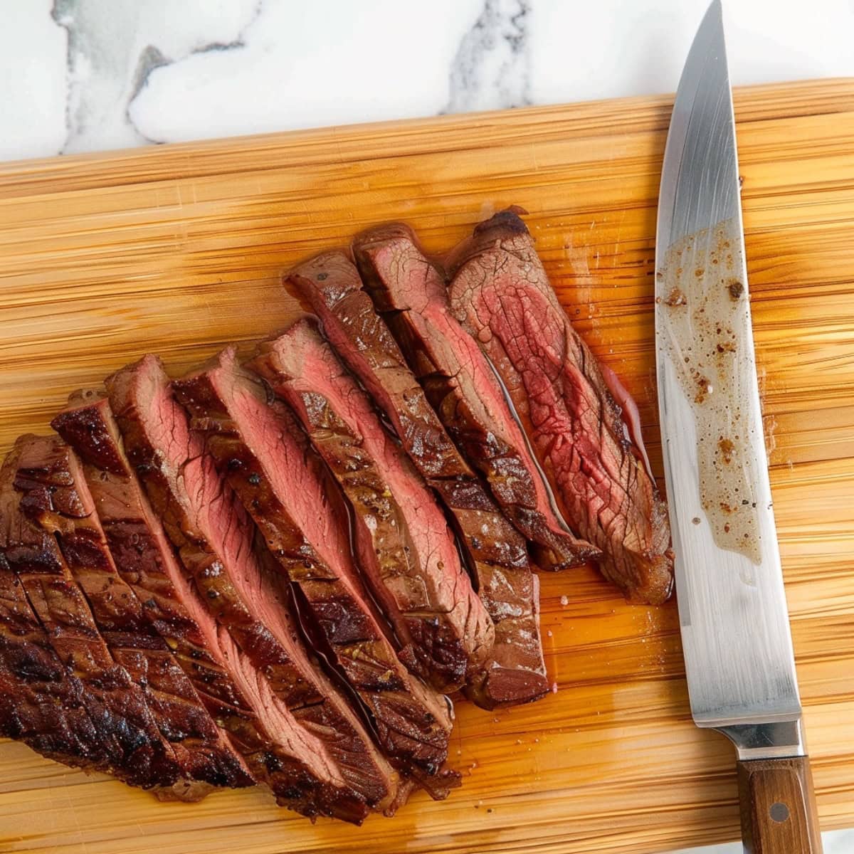 Cooked flank steak in a wooden board, top view 