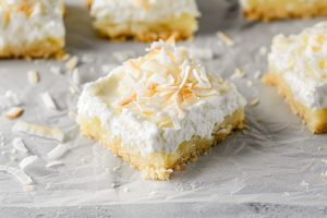 A detailed shot of coconut cream pie bars with a buttery crust and creamy coconut filling.