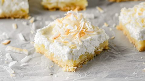 A detailed shot of coconut cream pie bars with a buttery crust and creamy coconut filling.