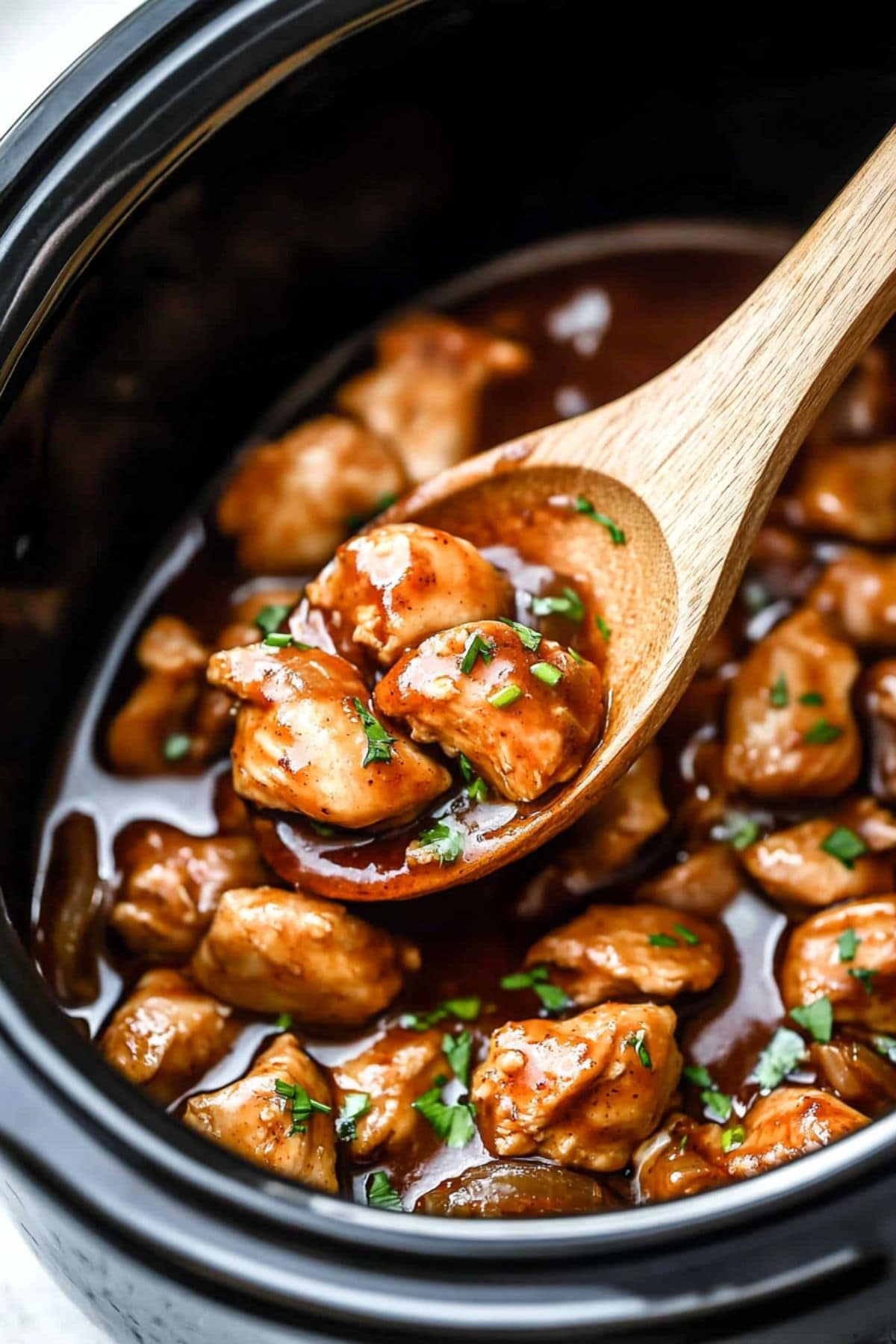 Bite sized chicken thigh cooked with bourbon infused sauce in a slow cooker.