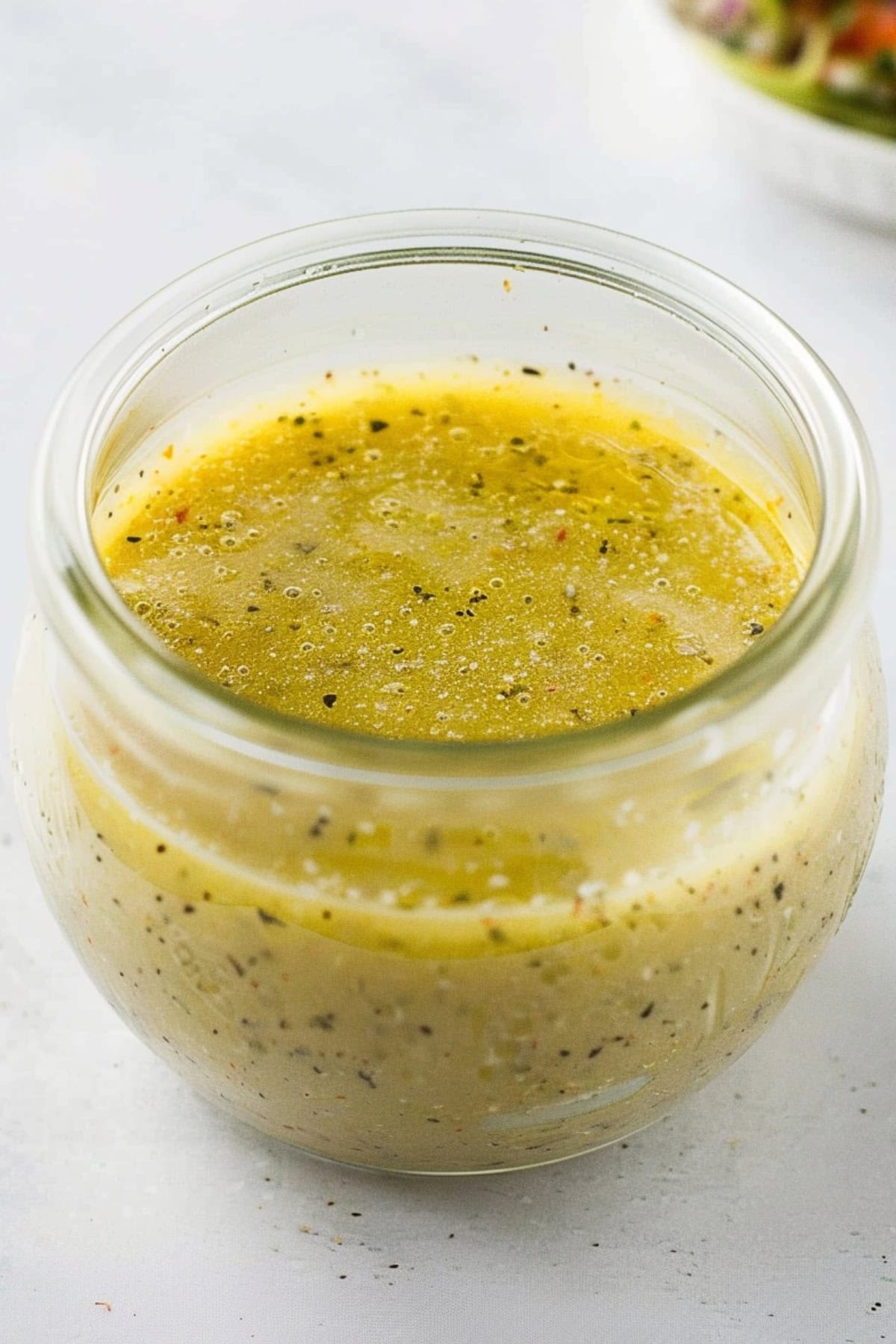 Seasoned Olive Garden dressing in a small jar.