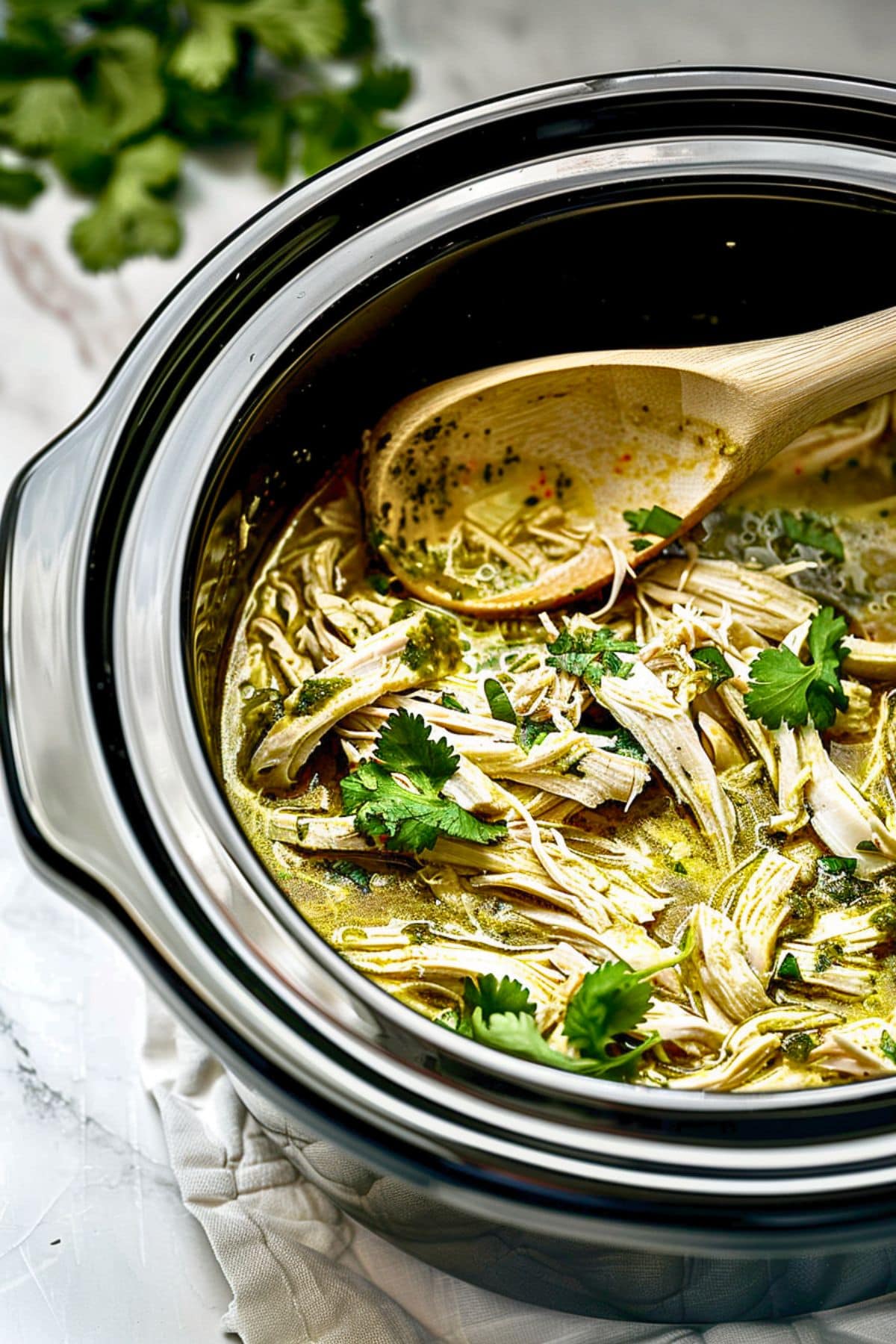 Shredded chicken with salsa verde in a crockpot.