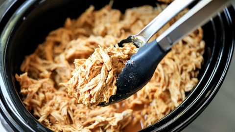 Shredded chicken cooked in a slow cooker crockpot.