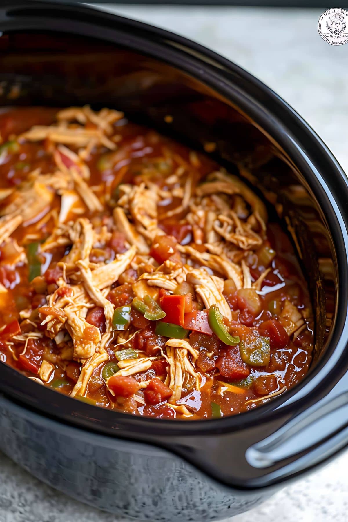 Chicken shredded cooked in salsa on a slow cooker. 