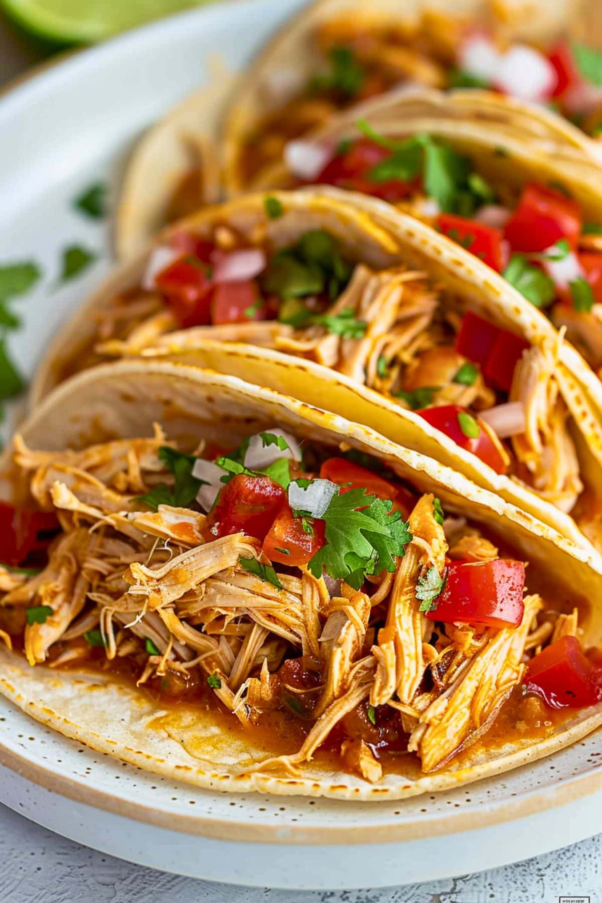 Chicken tacos in a Crockpot with a wooden ladle.