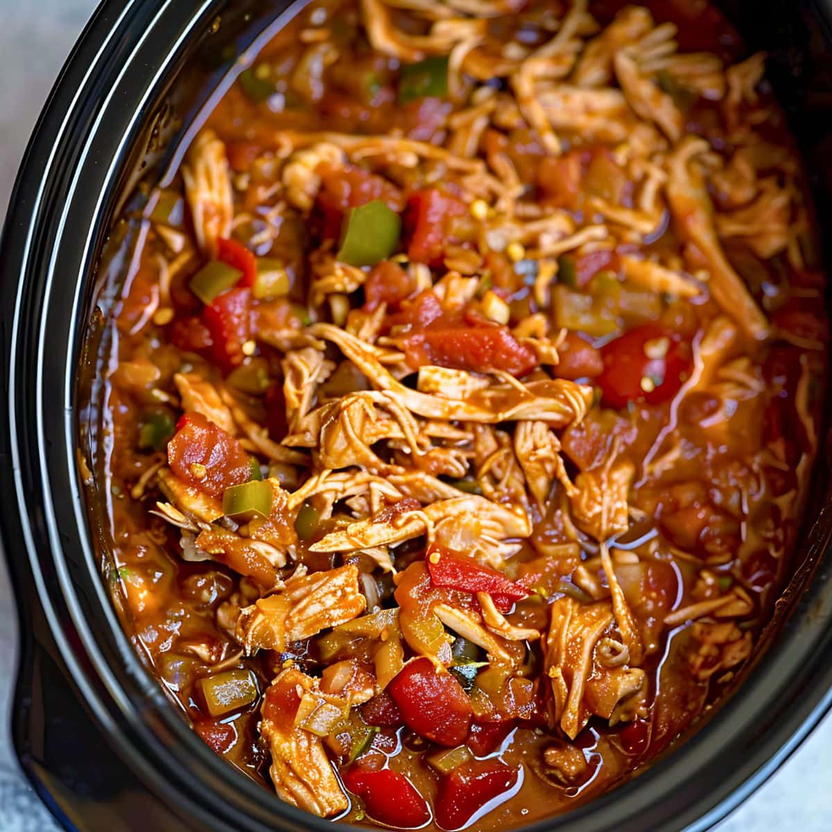 Shredded chicken with salsa and chiles on a crockpot. 