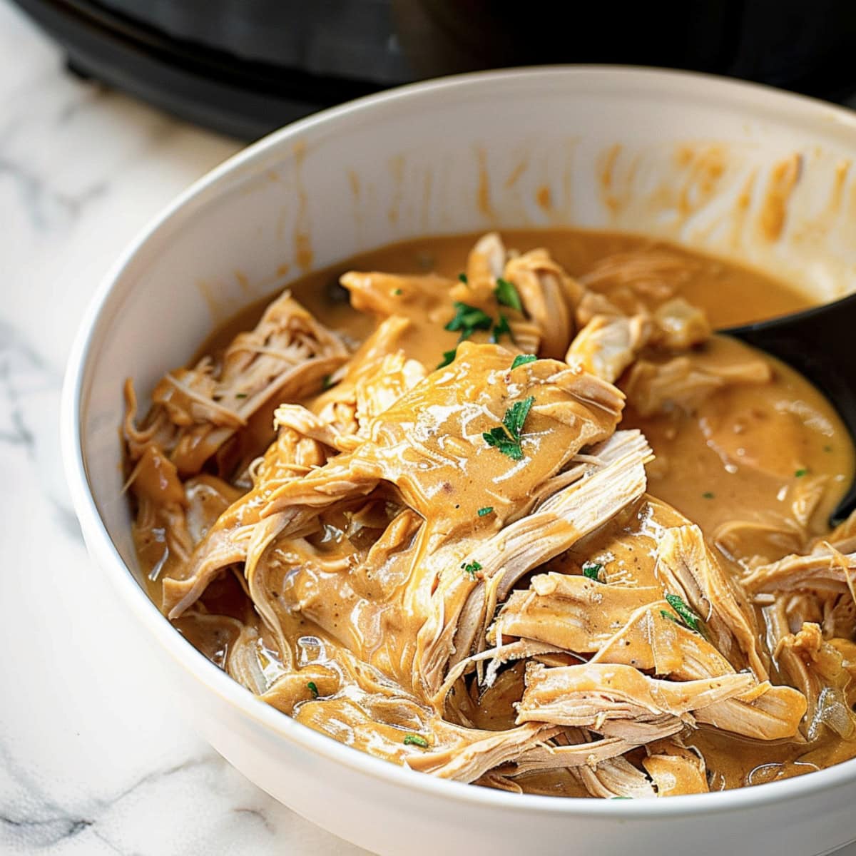 Crockpot chicken gravy served in a white bowl.