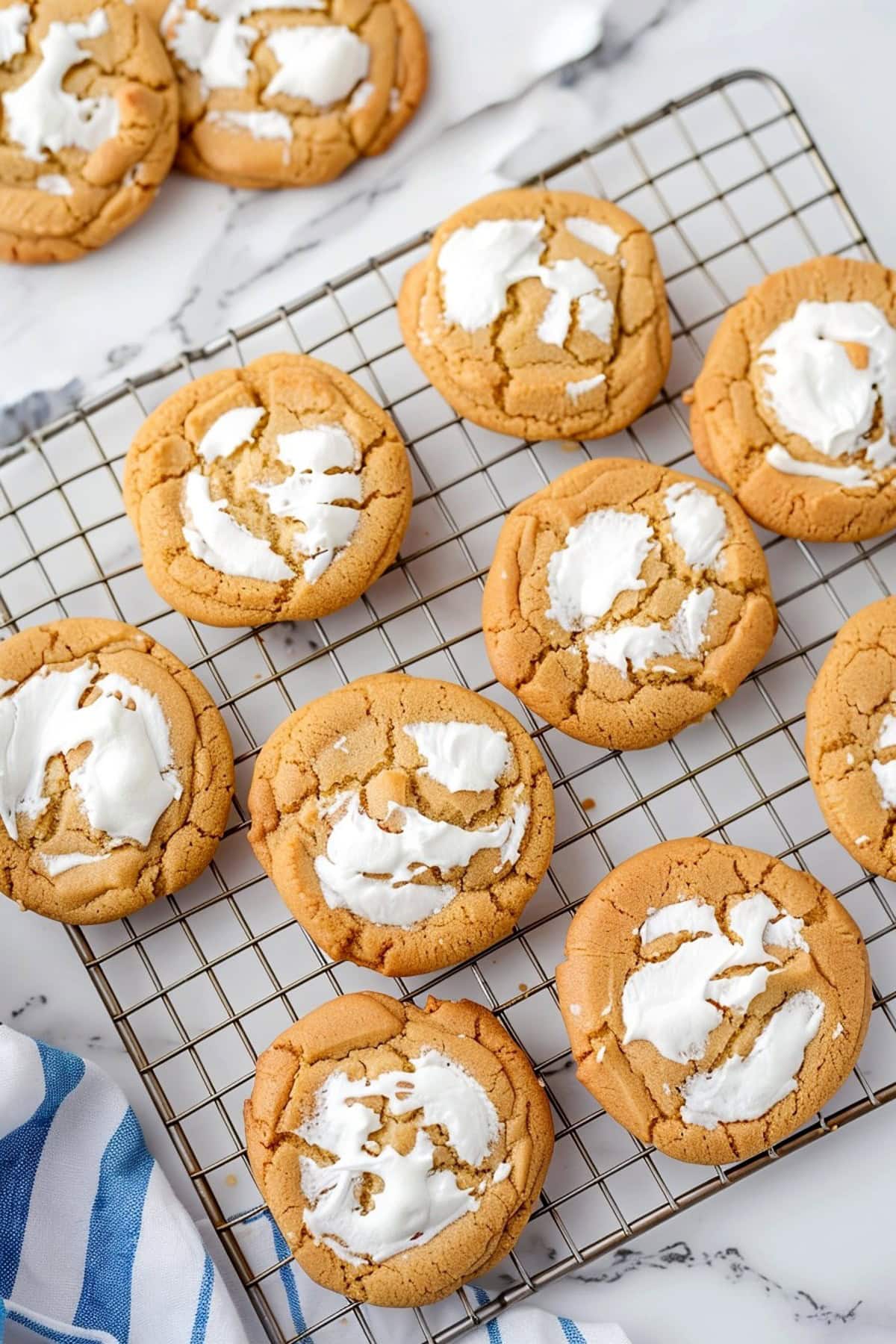 Homemade peanut butter cookies filled with marshmallow fluff in a cooling rack.