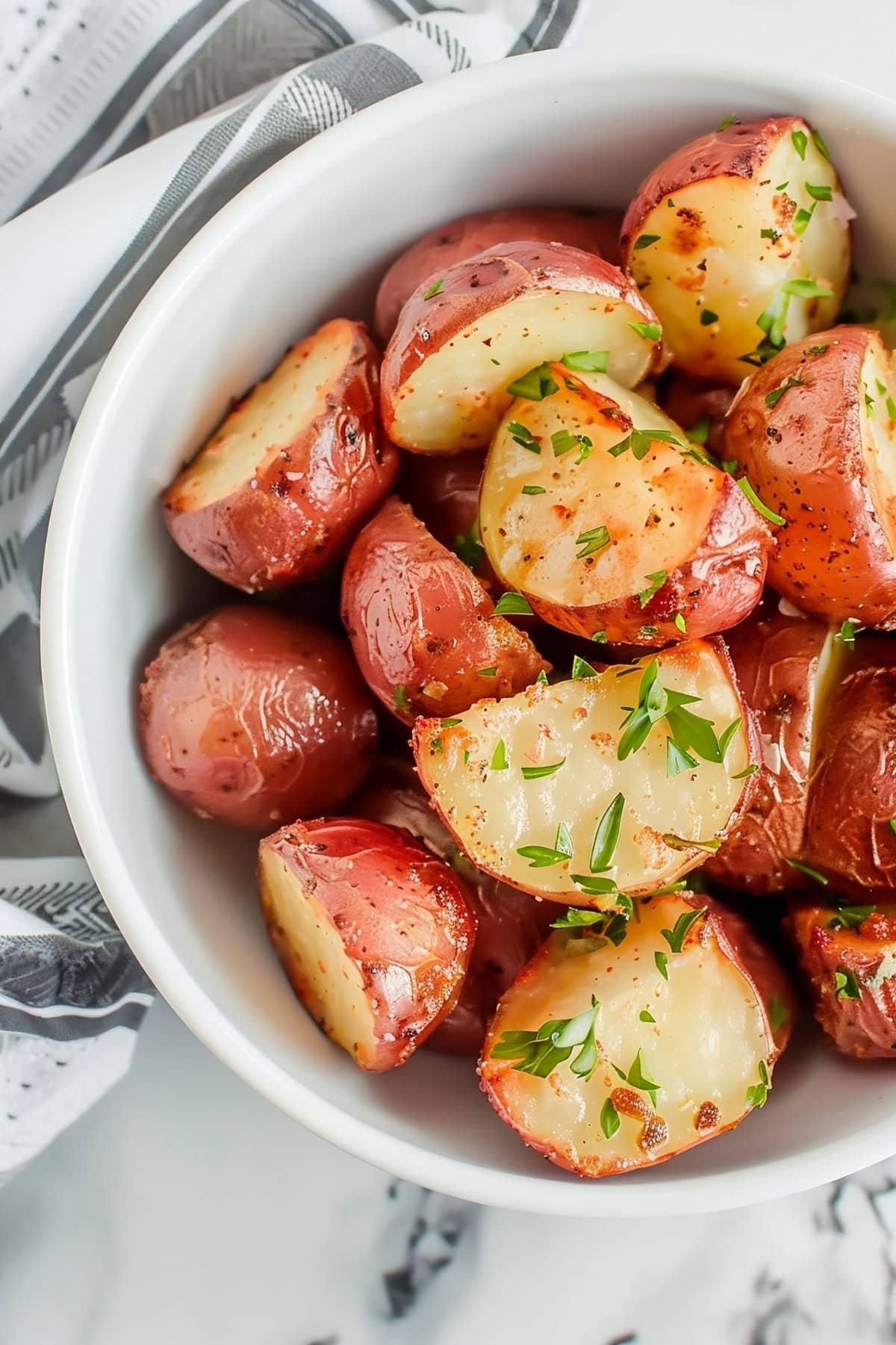 Tasty ranch roasted potatoes in a white bowl, top view