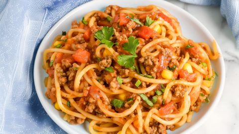 Homemade Mexican spaghetti Vibrant Mexican spaghetti, topped with diced tomatoes and fresh cilantro.