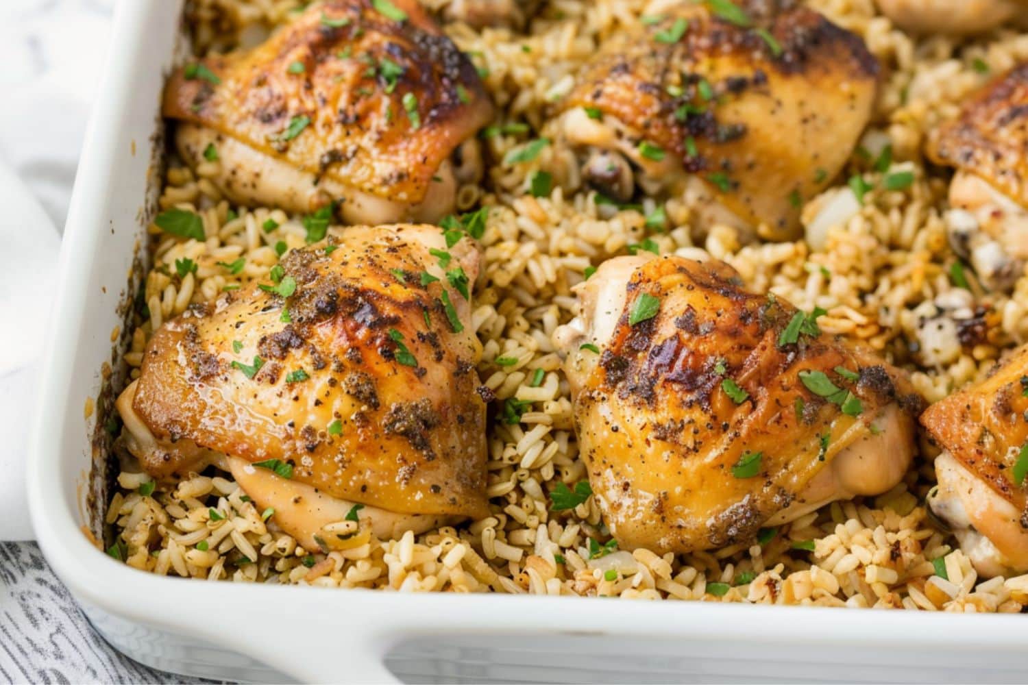 Oven baked chicken and rice in a baking dish.