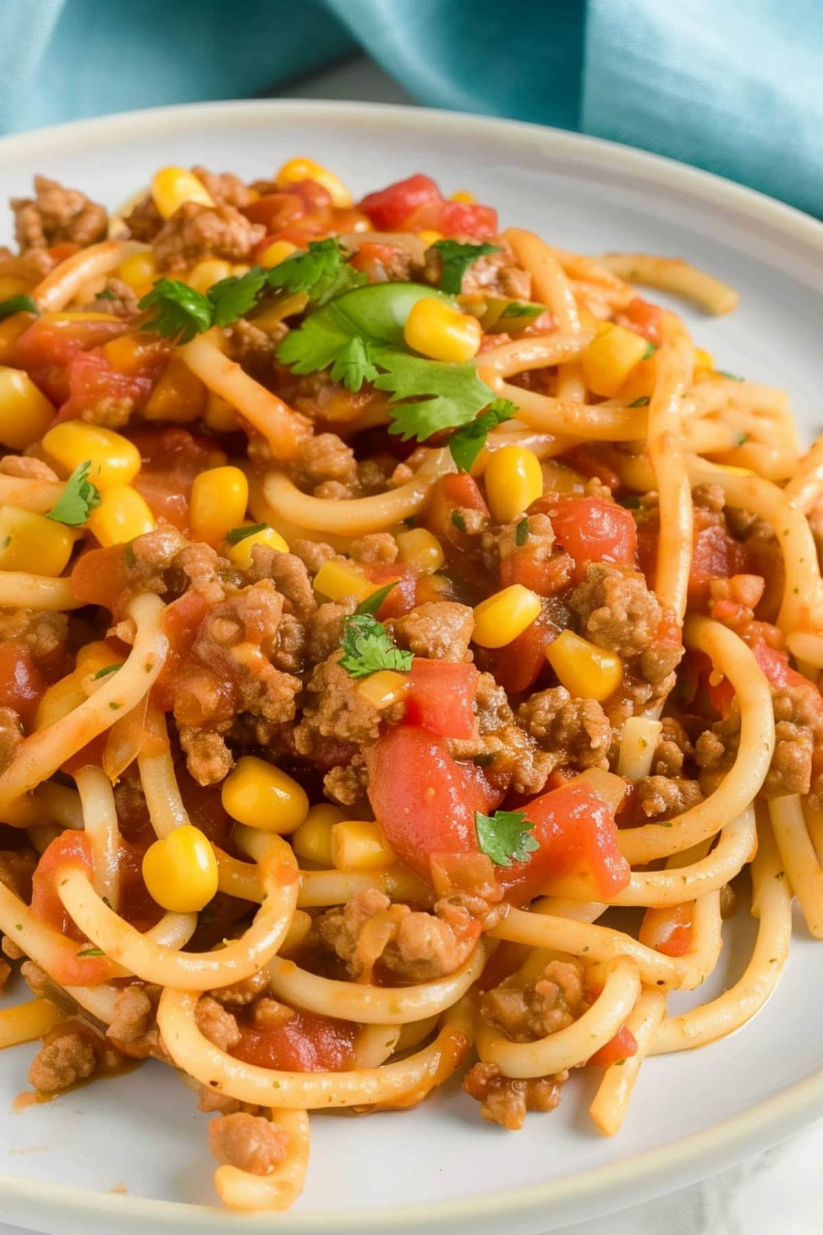 Homemade Mexican-style spaghetti  with corn and ground beef, garnished with cilantro.