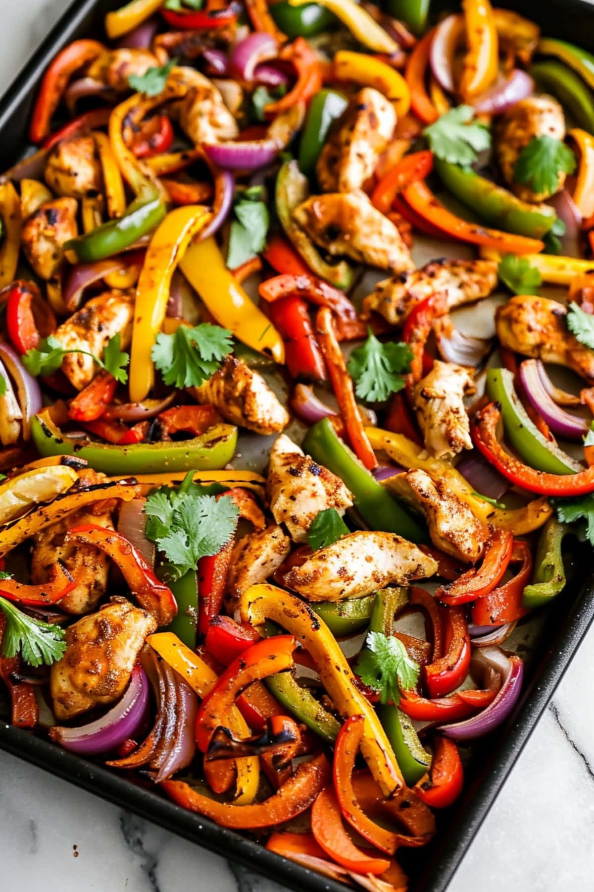 Classic sheet pan chicken fajitas with red, yellow and green bell peppers.