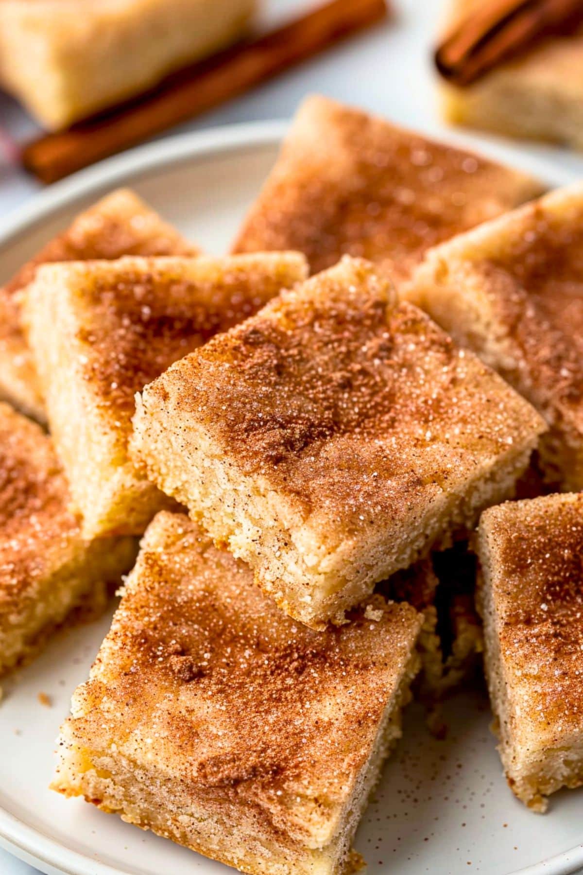 Square slices of snickerdoodle bars served on a white plate.