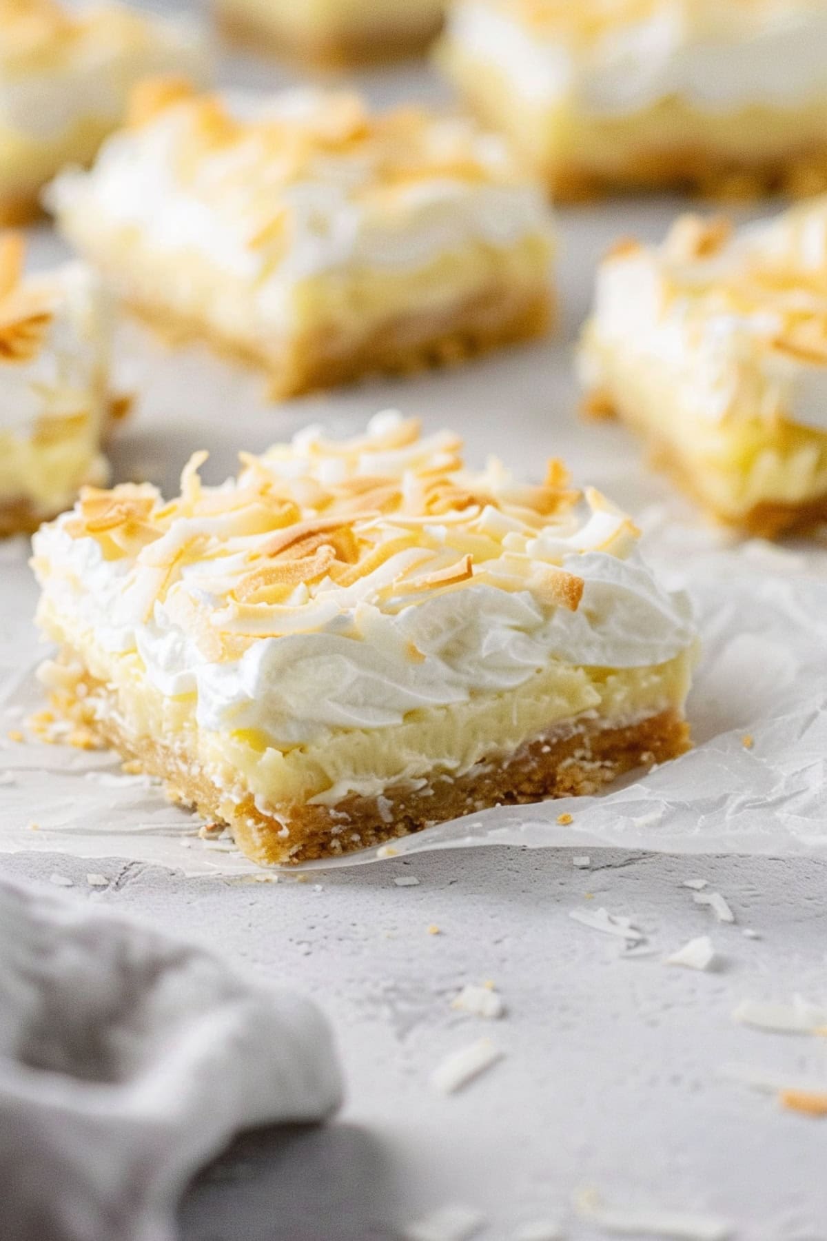 Creamy coconut pie bars with coconut shavings and whipped cream