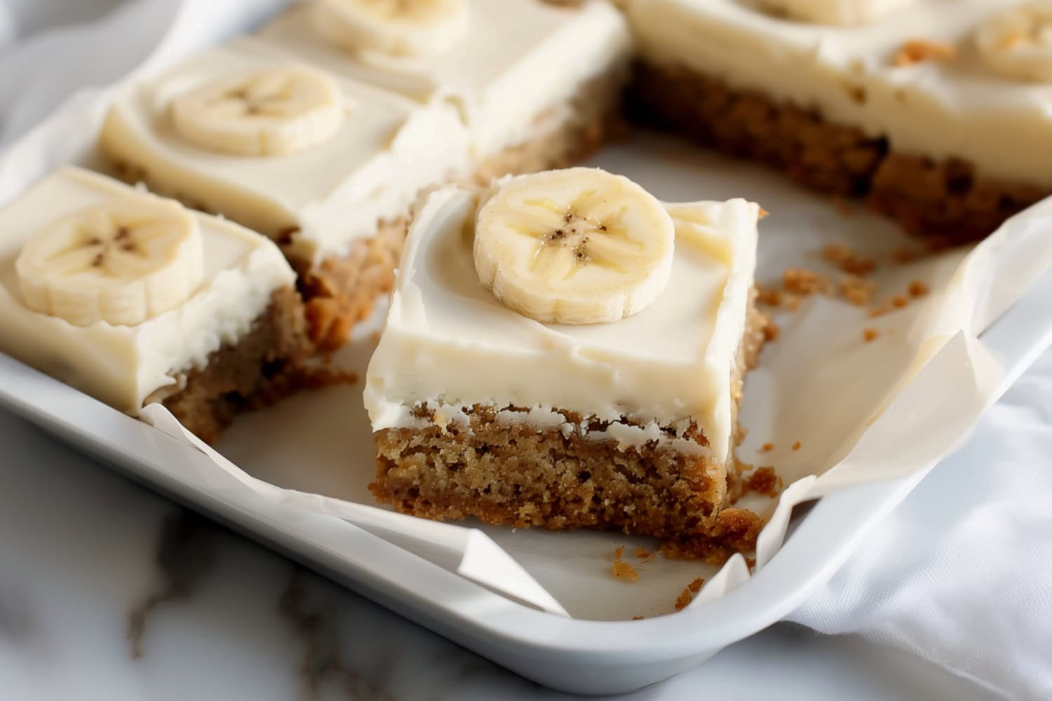 Freshly baked banana cake with a golden brown crust topped with cream cheese frosting.