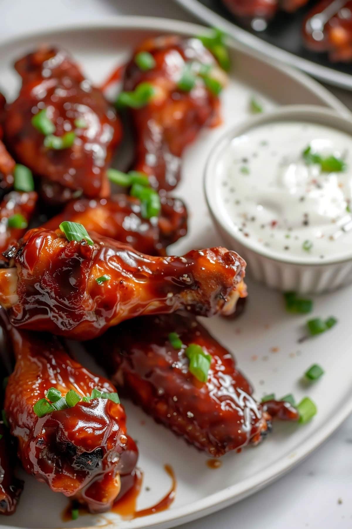 BBQ Chicken Wings Served with Sauce in a White Plate.