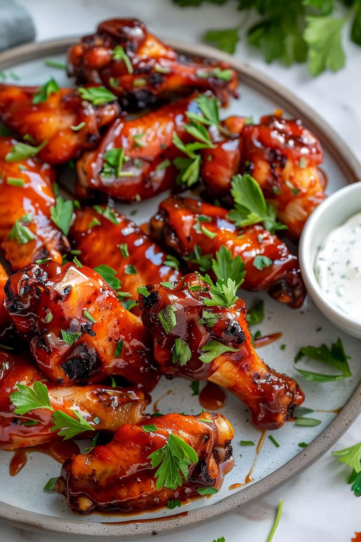 Juicy BBQ chicken wings served on a platter with dipping sauce..