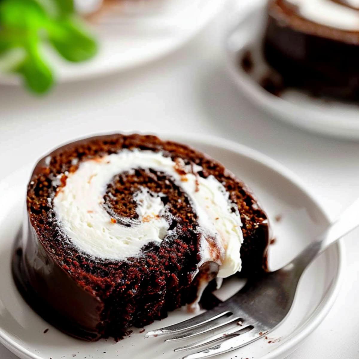 A slice of chocolate Swiss roll cake with creamy filling.