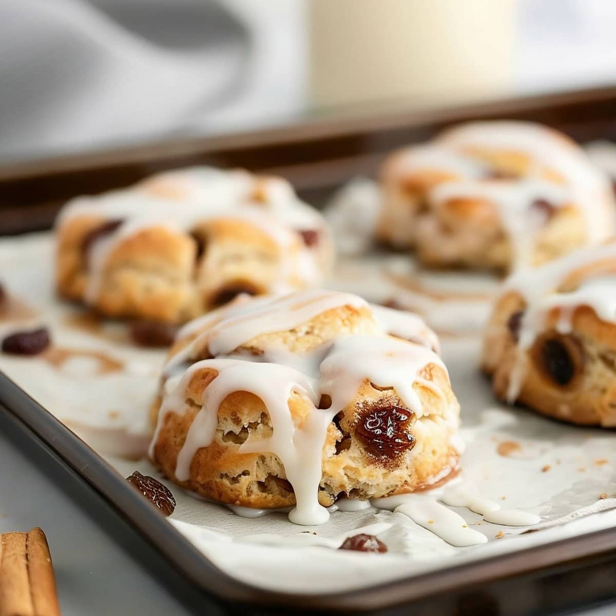 Cinnamon Raisin Biscuits on a Baking Sheet with Vanilla Glaze.