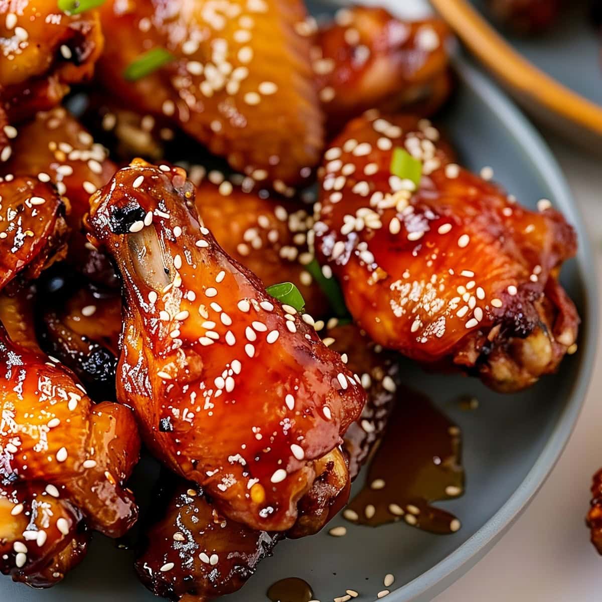 Honey Glazed Chicken Wings in a gray plate garnished with sesame seeds.