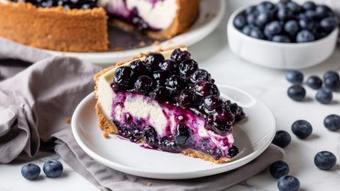 Lemon Blueberry Cheesecake slice in a white plate.
