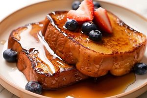 Delicious sheet pan French toast in a plate, featuring a crispy edge and a fluffy interior.