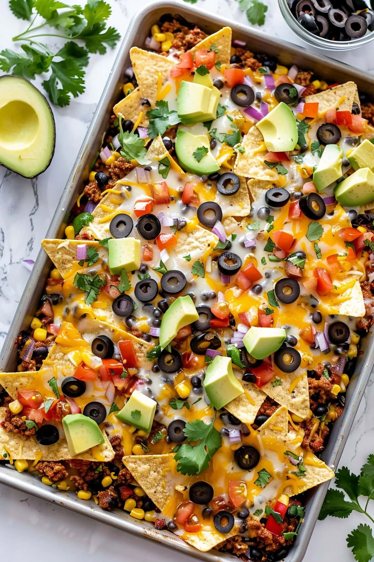 Sheet Pan Nachos with Avocados, Black Olives, Cheese and Tortillas