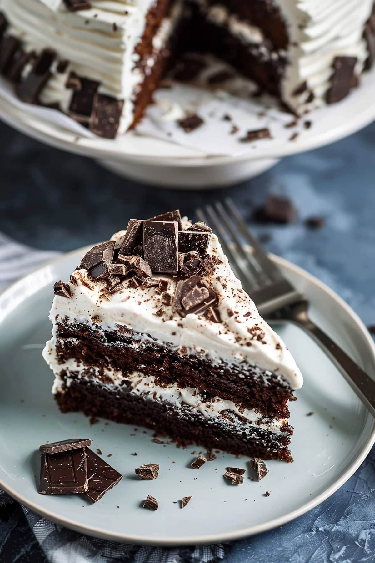 Slice of Hershey bar cake on a plate with chopped chocolate, top view