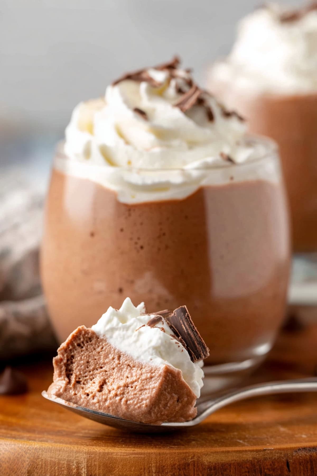 Bailey's chocolate mousse with whipped cream and chocolate shavings in a spoon.