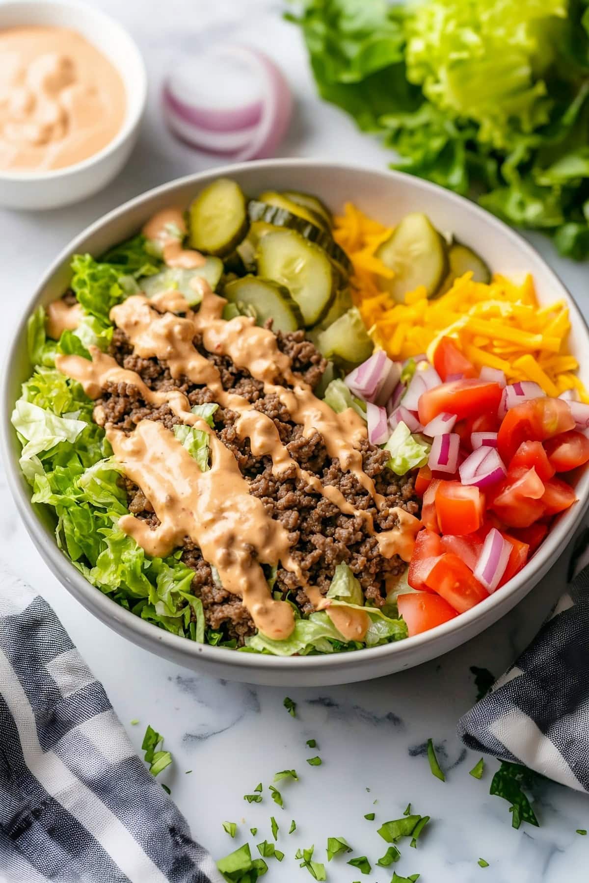 Big Mac bowl with seasoned beef, shredded lettuce, and a drizzle of sauce.