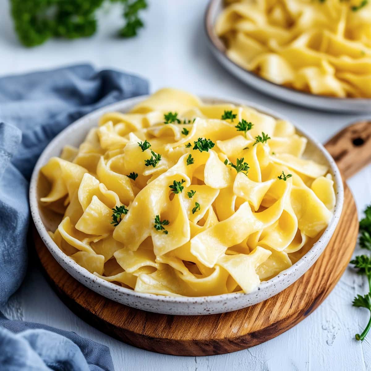 Creamy and buttery homemade cafeteria noodles in a white plate.