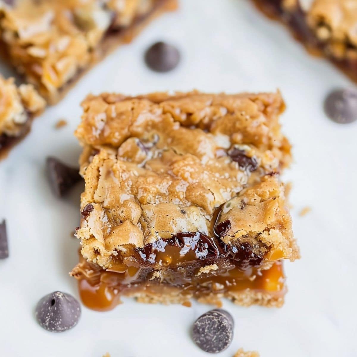 Slice of carmelitas with chocolate chips on a white surface, close up