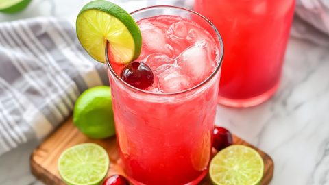 Refreshing homemade iced cherry limeade in a wooden board.