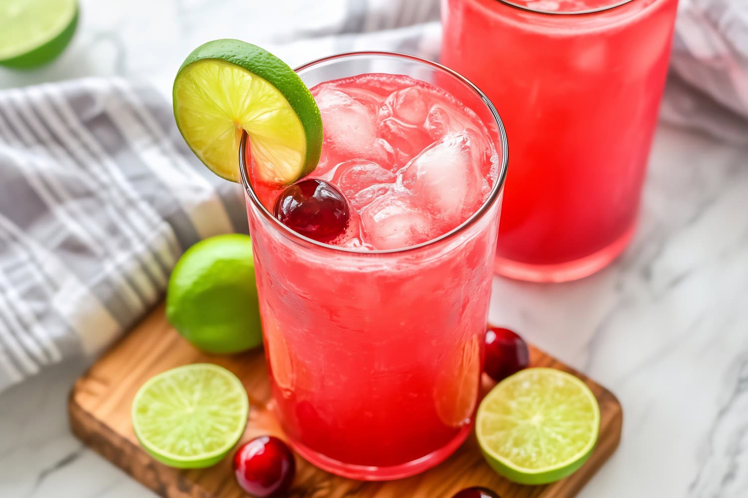 Refreshing homemade iced cherry limeade in a wooden board.