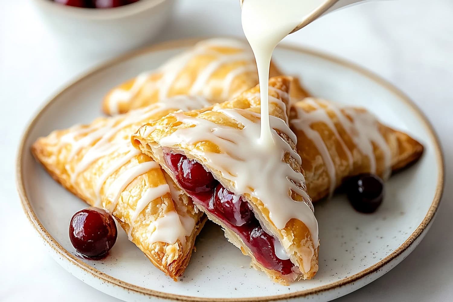 Homemade cherry turnovers with a glossy glaze and chunks of juicy cherries.