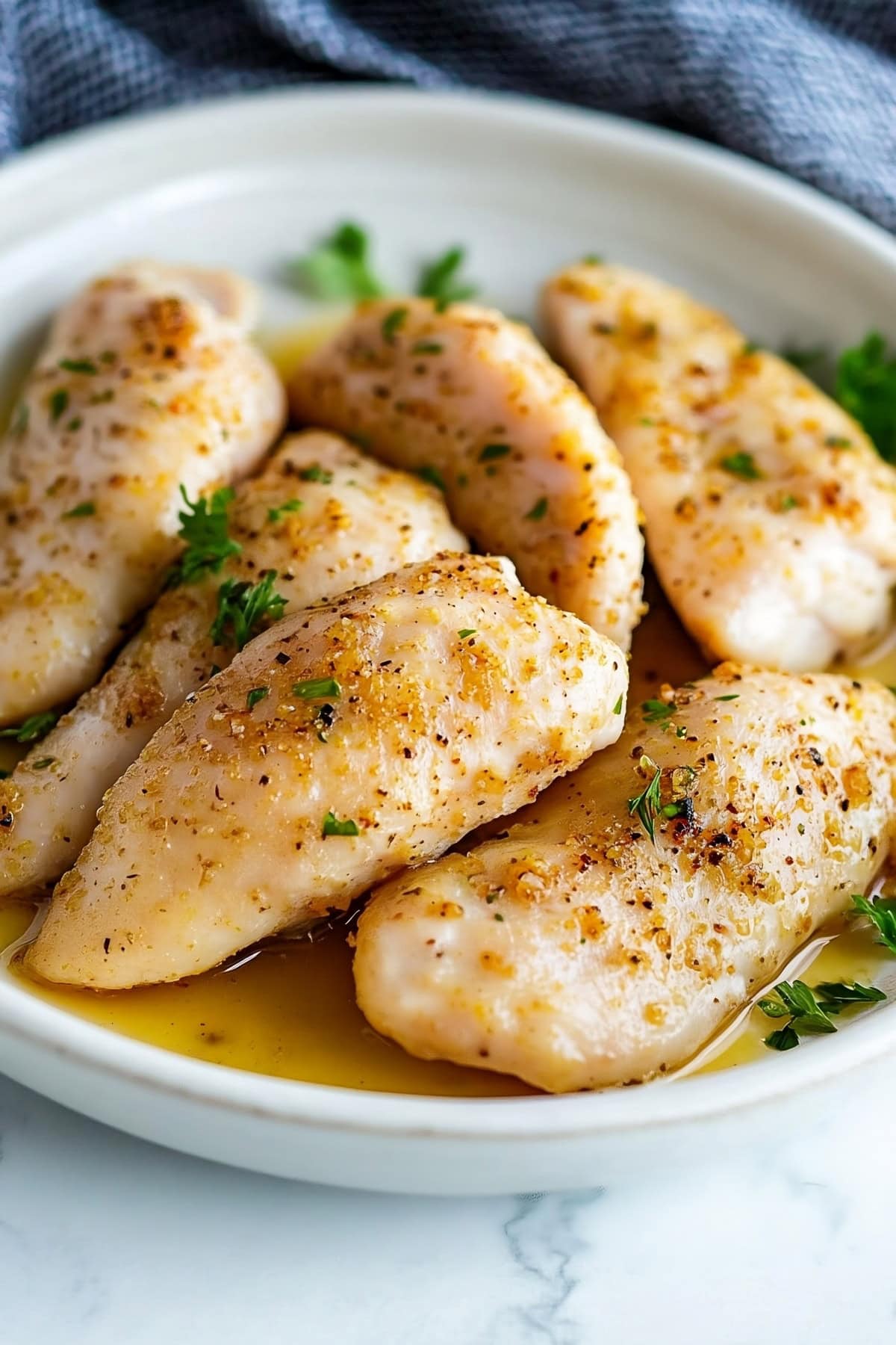 Marinated chicken tenderloins in a plate.